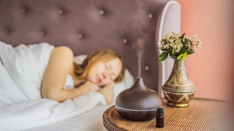 Woman sleeping beside an oil diffuser