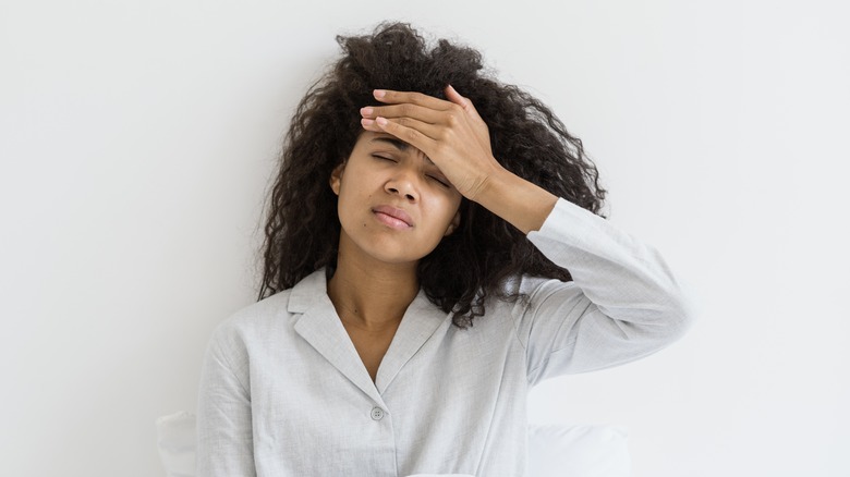 Woman with headache in pajamas