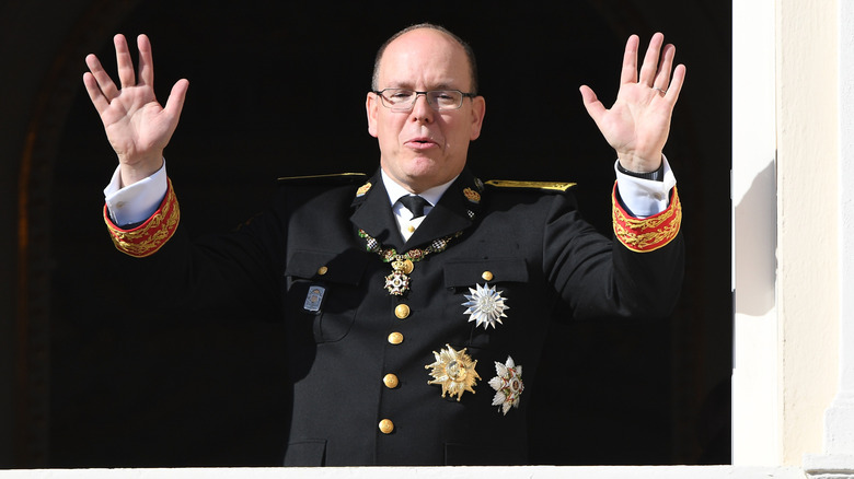 Prince Albert of Monaco holding hands up in a wave on the palace balcony in 2016