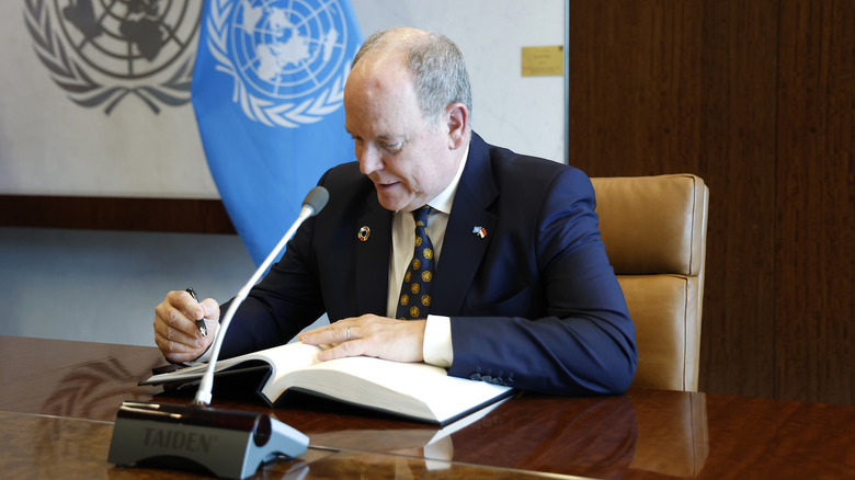 Prince Albert at the UN writing in a book