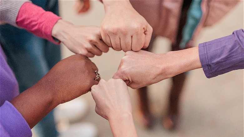 Women's hands in fists together