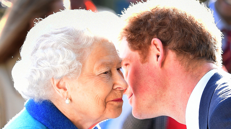 Prince Harry leans over to kiss the queen