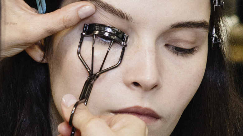 Model using eyelash curler 