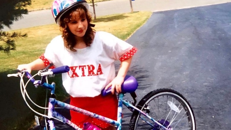 Melissa Rauch as a teen with a bike