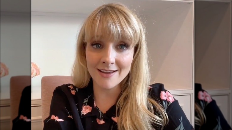 Melissa Rauch in a black and pink blouse