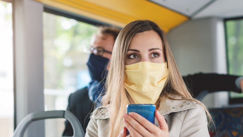 Woman wearing a mask properly on a bus