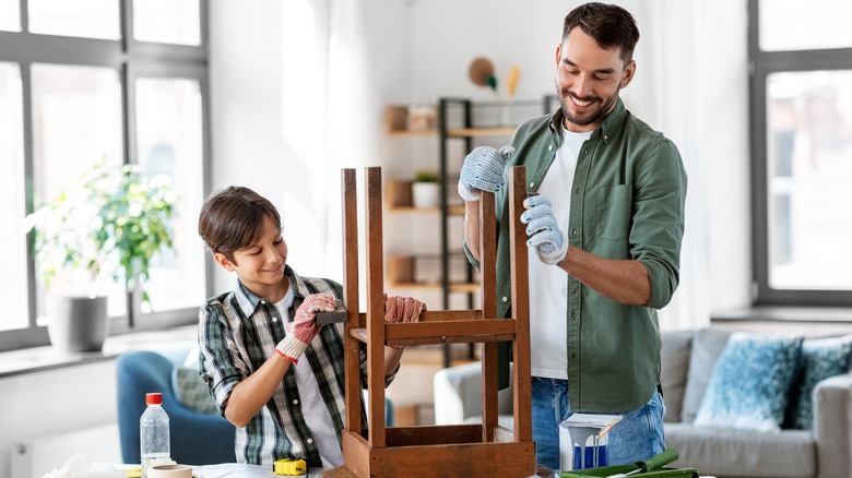 kid and father repairing table together