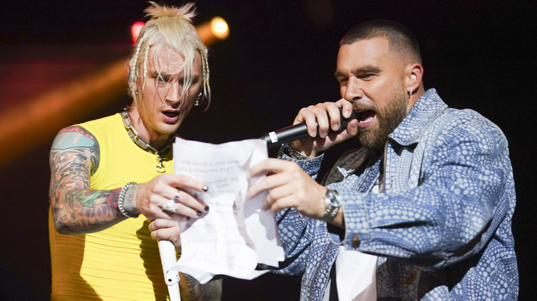 MGK and Travis Kelce performing and reading a sheet of paper