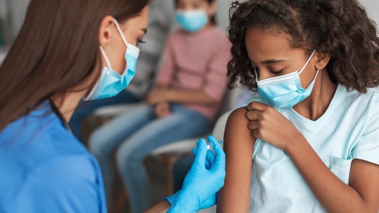 doctor giving child vaccine