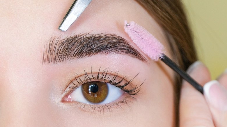 Woman doing her eyebrows