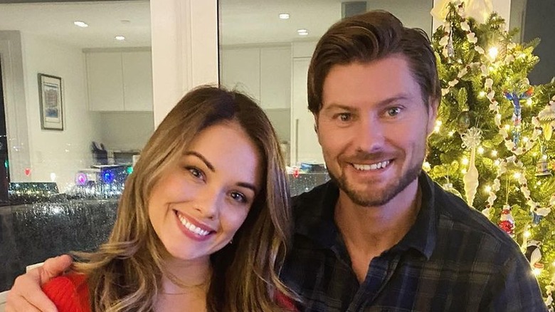 Stephanie Bennett and Sebastian Gacki in front of a Christmas tree