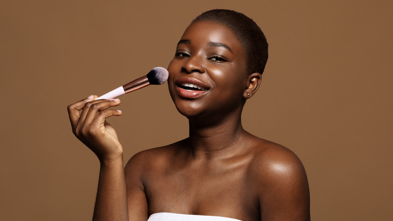 woman dusting on makeup