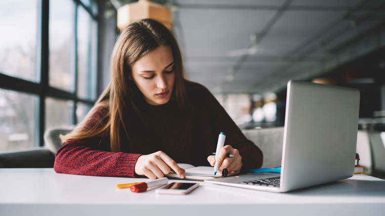 A woman writing something in a journal