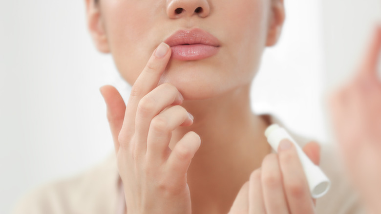 Pouting while applying lip balm 