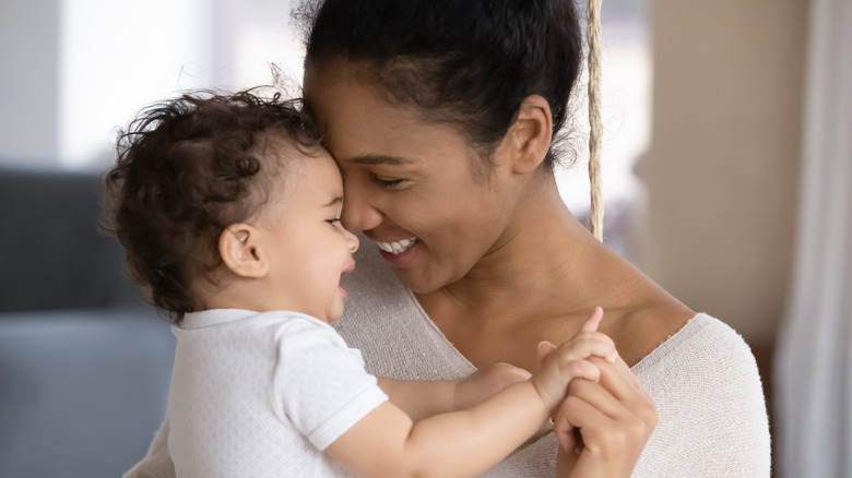 Woman smiling and hugging baby