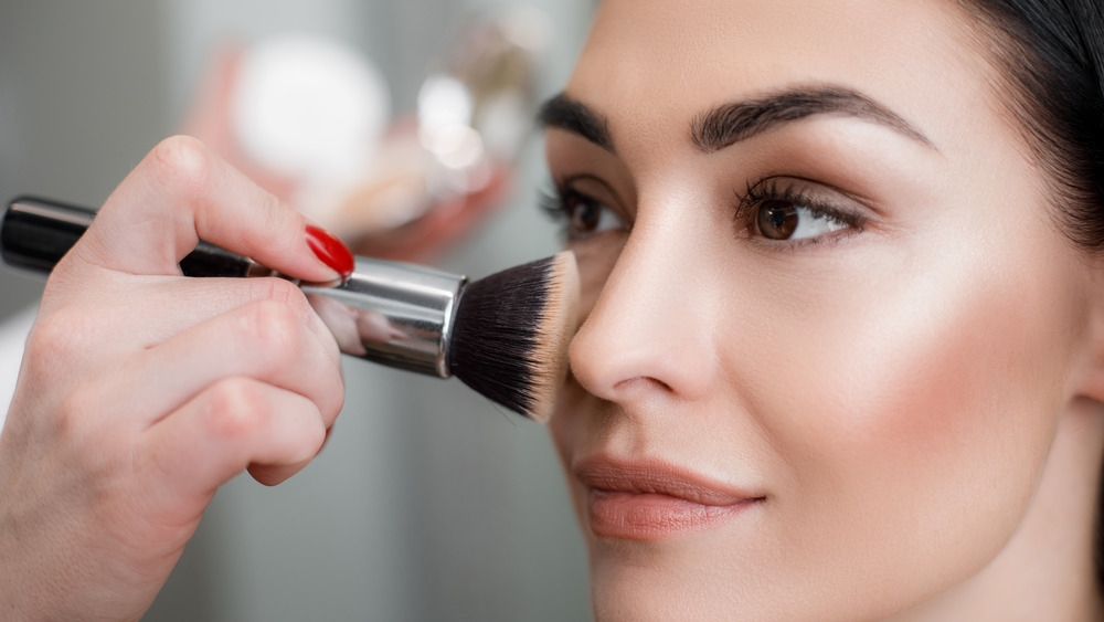 Woman applying makeup with brush