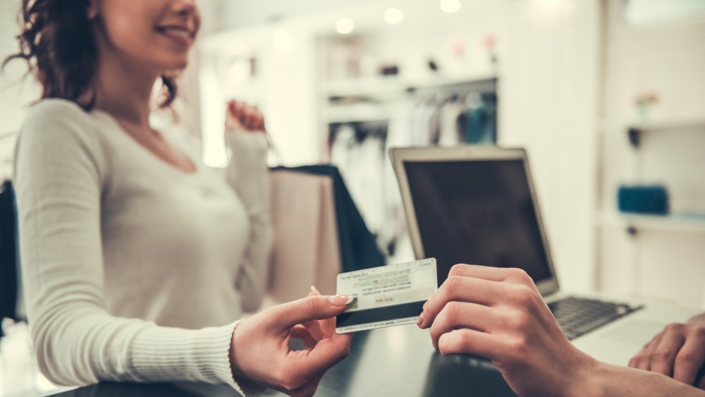 Woman giving a credit card to a cashier