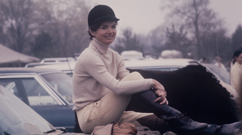 Jackie Kennedy sitting on a car 