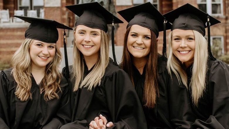 Karoline Leavitt at far right in cap and gown with three friends smiling at St. Anselm College graduation