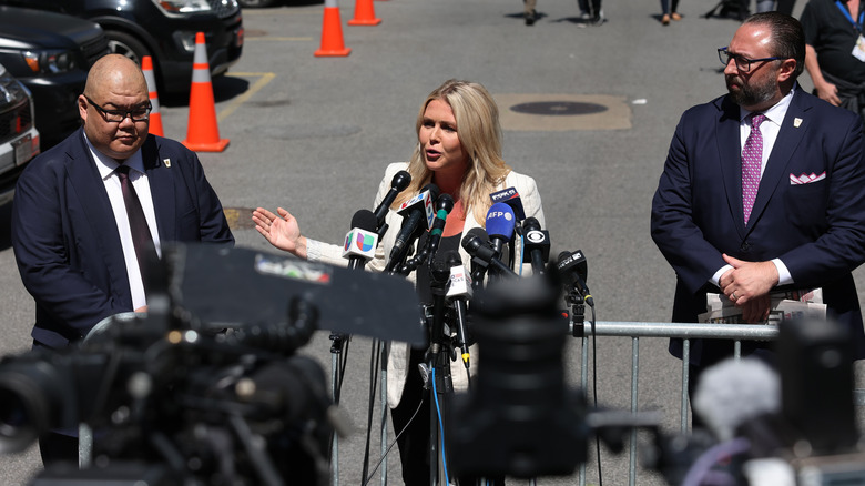 Karoline Leavitt in beige jacket speaking at a press conference