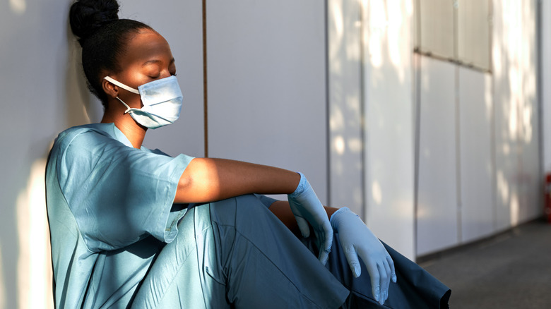 Tired nurse in blue scrubs 