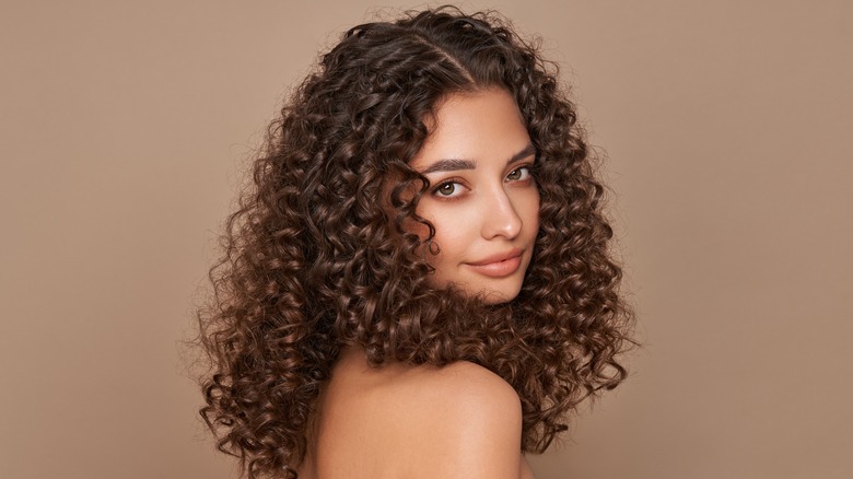 woman with curly hair looking to side