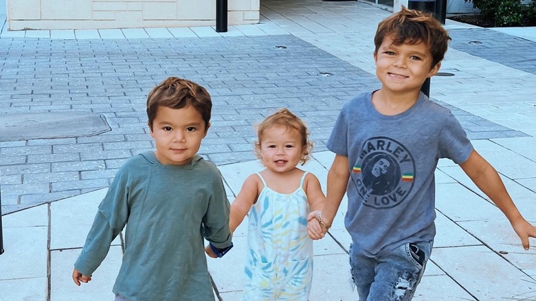 Kingston, Rio, and Ocean PenaVega holding hands and smiling