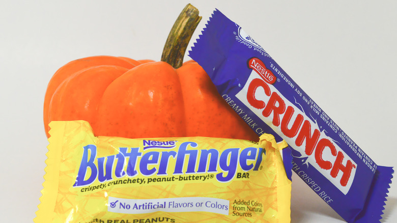 Butterfinger and Nestle Crunch laying on a pumpkin