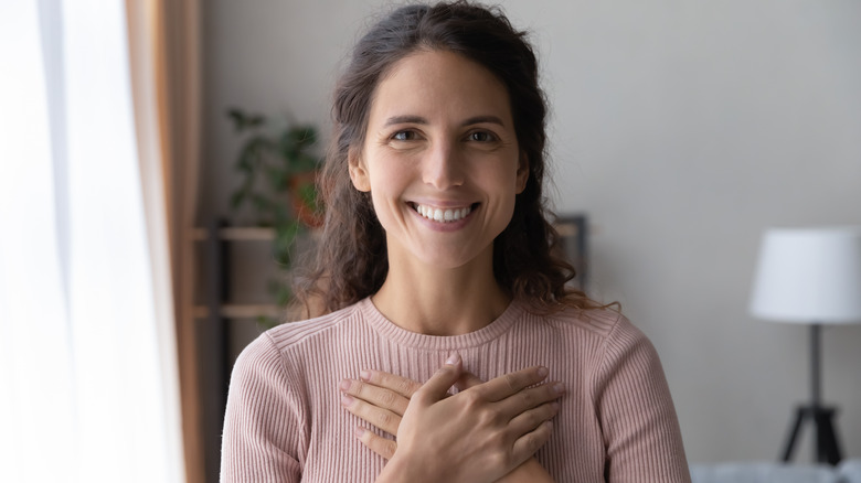 happy woman touching heart