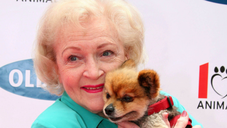 Betty White snuggling dog