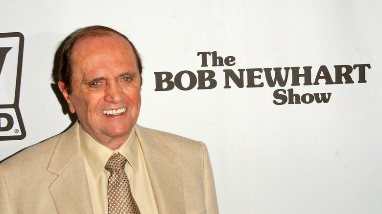 Bob Newhart posing with show logo