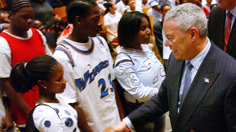 Colin shaking the hand of a basketball player