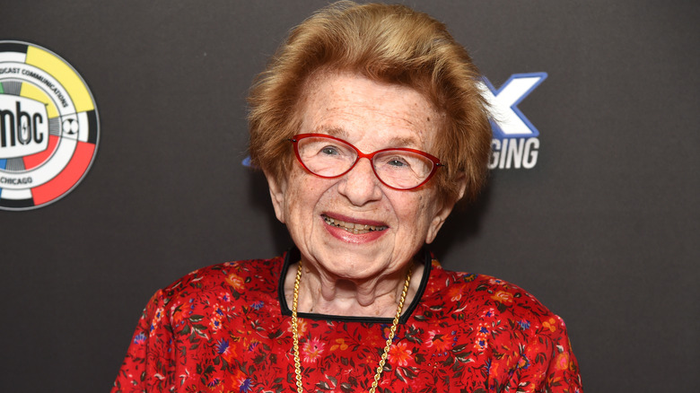 Dr. Ruth smiling in red glasses