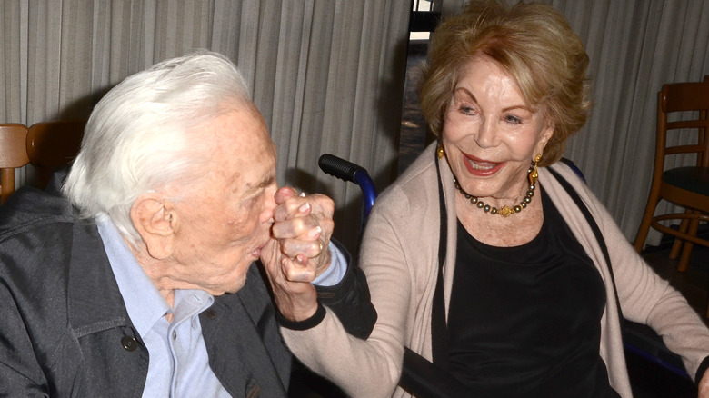 Kirk Douglas kissing Anne Douglas' hand