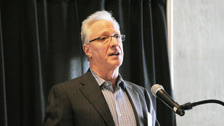 Robert LuPone speaking at a microphone