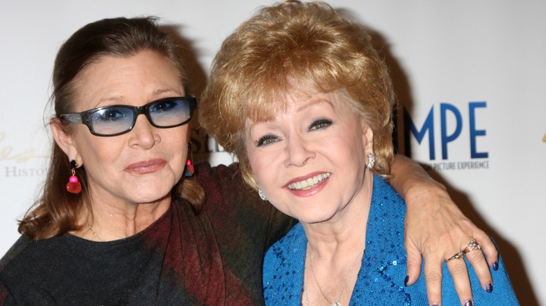 Carrie Fisher with her arm around Debbie Reynolds