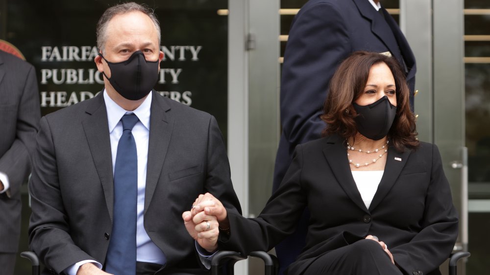 Kamala Harris and Doug Emhoff holding hands and wearing masks 