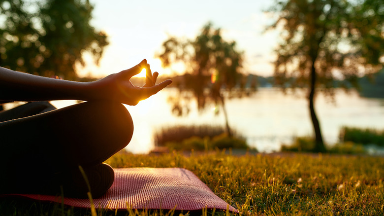 Woman meditating by river