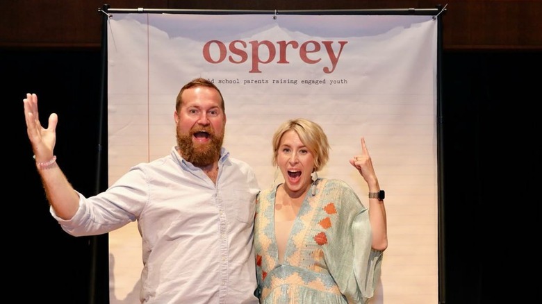 Ben and Erin Napier posing in front of an Osprey backdrop