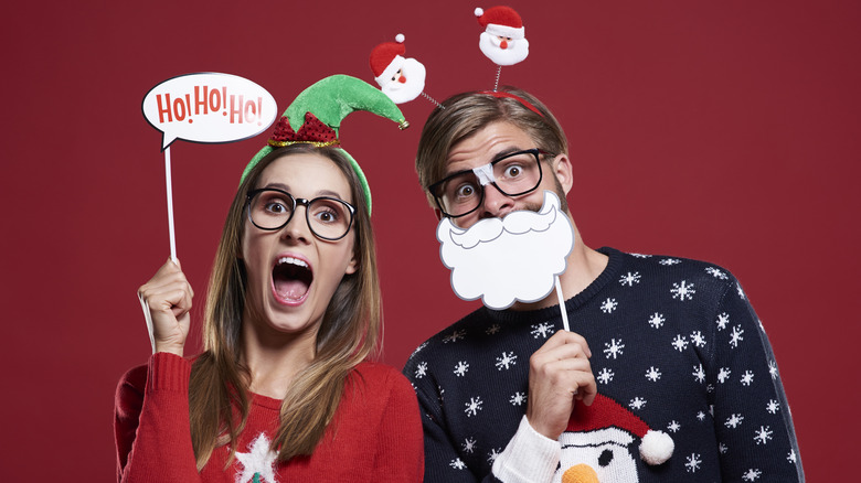 couple wearing Christmas sweaters