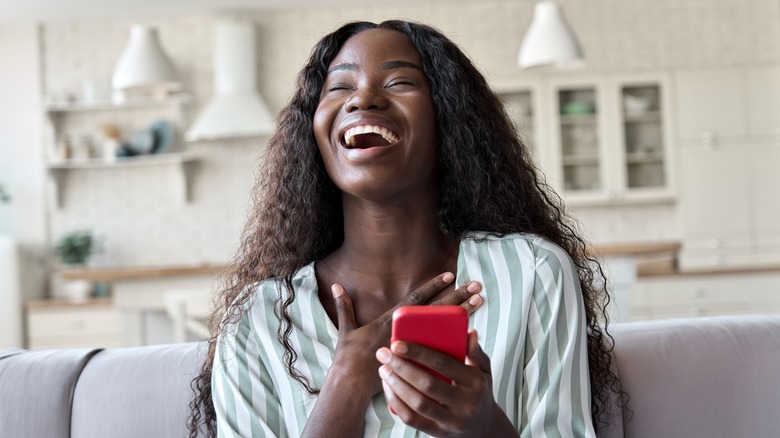 women laughing with phone in her hand