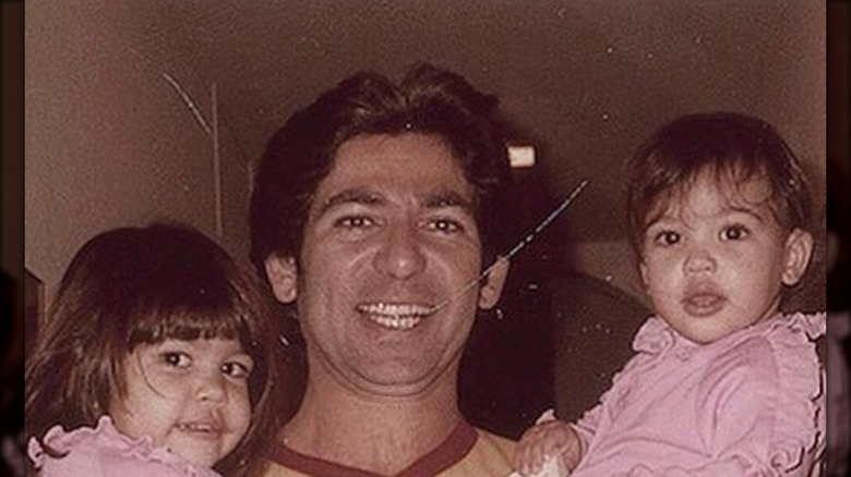 Robert Kardashian holding two of his daughters