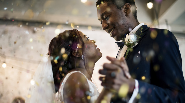 Couple dances at their wedding, confetti falls around them