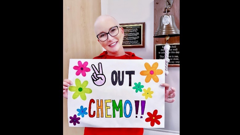 Clea Shearer holding sign celebrating end of chemotherapy