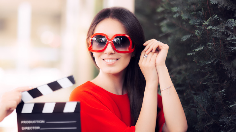 Actress wearing big red sunglasses