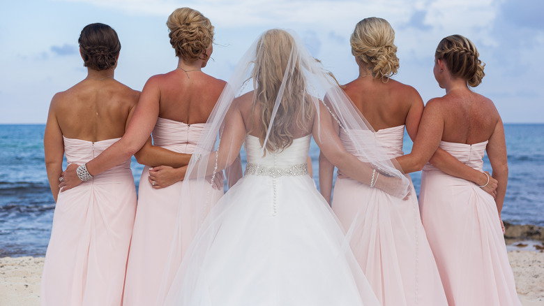 bride with bridesmaids on beach 