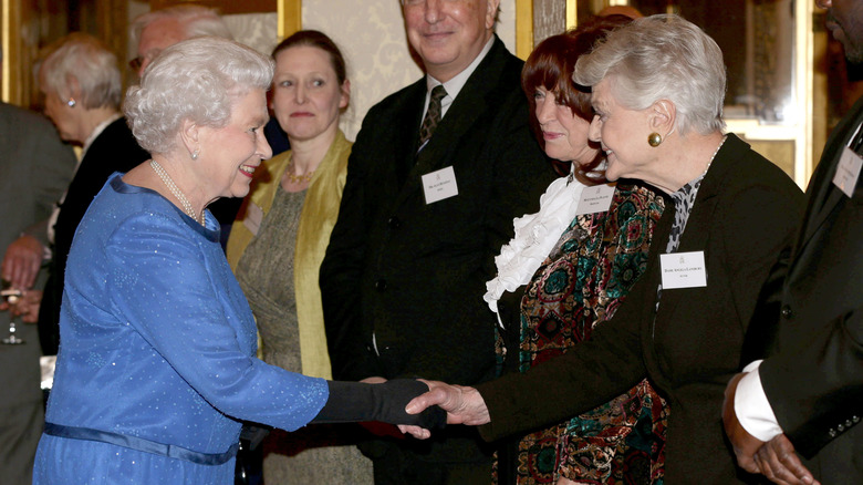 Queen Elizabeth shaking hands with Angela Lansbury