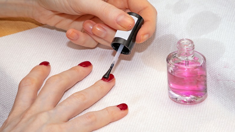 Woman applying a top coat of nail polish