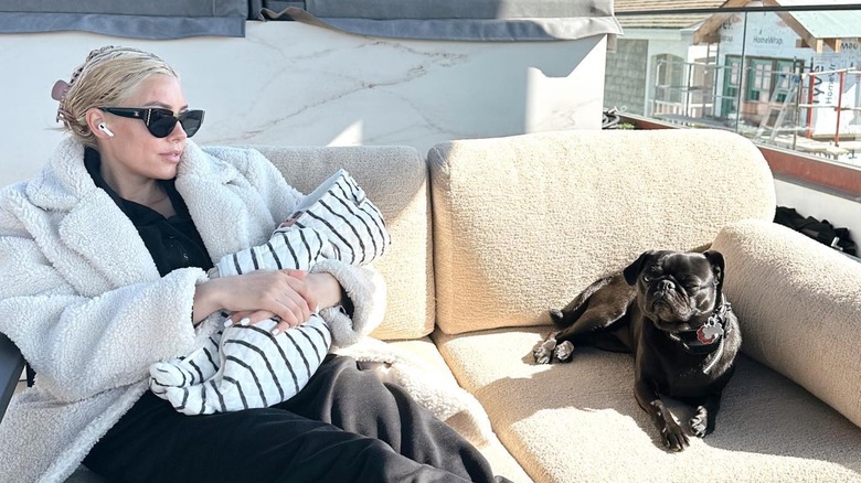 Heather Rae El Moussa sits with baby and dog on couch