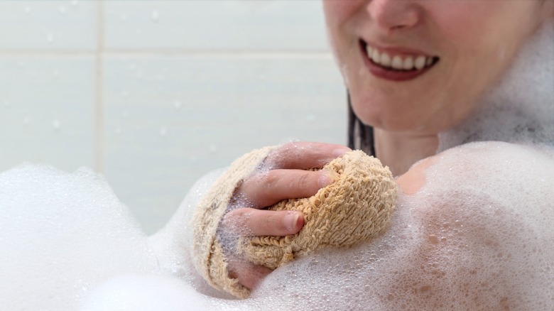 Woman bathing with bath sponge